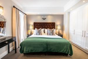 开普敦Romney Park Luxury Apartments的一间卧室配有一张带绿毯的大床