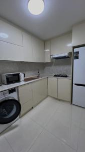 撒马尔罕Samarkand Central Apartments的厨房配有白色橱柜和白色冰箱。