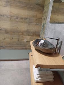 苏萨Agriturismo al pra di muriet的木制柜台上带石水槽的浴室