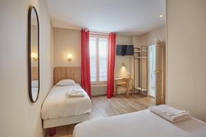 巴黎巴黎北站梅尔里勒酒店的一间卧室设有两张床、一张桌子和一个窗口。