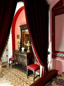 苏塞Dar Aziz的一间设有梳妆台和红色窗帘的房间