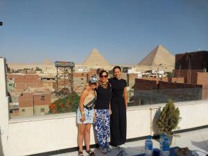 开罗Eagles Pyramids View的一群人站在屋顶上,背后有金字塔
