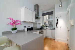 伦敦GuestReady - Stunning Covent Garden 2BR Duplex的厨房配有白色橱柜和白色台面