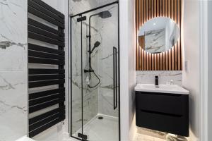 伦敦GuestReady - Stunning Covent Garden 2BR Duplex的带淋浴、盥洗盆和镜子的浴室