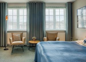 斯卡恩斯盖恩七彩酒店的一间卧室配有两把椅子和一张床,设有窗户。