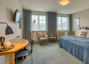 斯卡恩斯盖恩七彩酒店的酒店客房带一张床、一张桌子和椅子