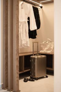 波利克罗诺Ikyma Boutique的一间房间,带行李箱和白色衬衫及鞋子