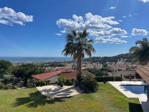 Vilassar de DaltPalm Maresme - Suite with bathroom and living-room and terrasse with ocean views in a private villa的房屋前的棕榈树