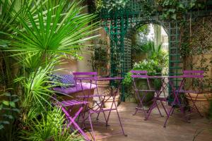巴黎香榭丽舍大道伽利略酒店的花园里的一套紫色椅子和桌子