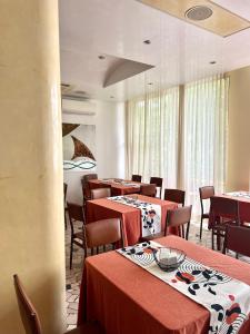 里米尼Hotel B&B Ardea Rimini的一间带桌椅和红色桌布的用餐室