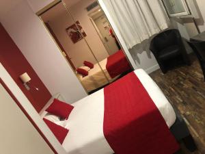 昂古莱姆Cit'Hotel Europeen的一间卧室配有一张带红色毯子和镜子的床