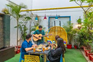 新德里goSTOPS Delhi的一群人坐在一张桌子旁弹吉他
