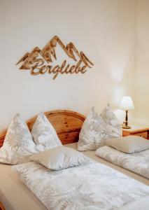 赖特附近圣格奥尔根Ferienwohnungen Baumann-Breitenberg的两张带白色枕头的床和墙上的标志