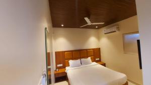 孟买HOTEL RIGGA INN KOKILABEN DHIRUBHAI AMBANI Hospital的卧室配有白色床和天花板