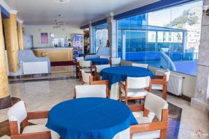 科帕卡巴纳拉戈阿祖尔酒店的一间设有蓝色桌子和白色椅子的餐厅