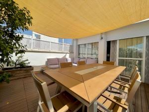 塞维利亚Luxury Duplex 200 M2 Terrace Parking StayInSeville的天井上配有一张大木桌和椅子