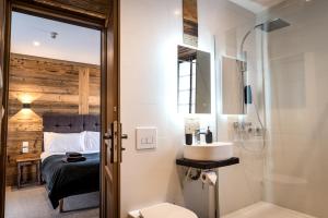 莫尔济讷Nant Morzine的一间带水槽和淋浴的浴室以及一张床