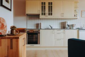 茨维泽尔Lindenhaus的厨房配有白色橱柜和炉灶烤箱。