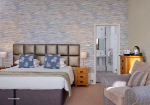 法尔茅斯理查德森法尔茅斯酒店的一间卧室配有一张床、一张沙发和一把椅子