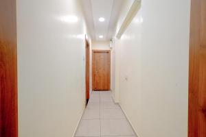 乌贾因FabExpress SK Prime的一条带白色墙壁和木门的走廊
