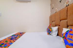 乌贾因FabExpress SK Prime的一间卧室配有带色彩缤纷枕头的床