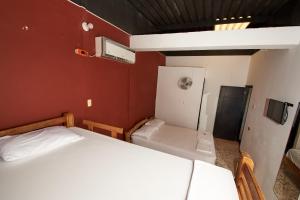 CamaronesHotel flamencamarones的小房间设有两张床和一台冰箱