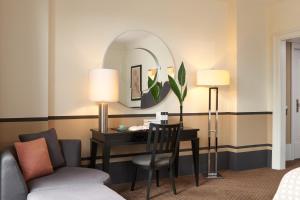 柏林罗马罗科·福尔蒂酒店的酒店客房配有书桌和镜子
