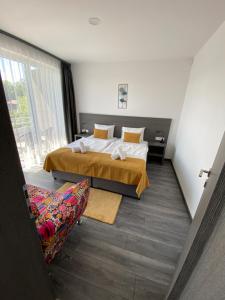 乔保克HOTEL CSOPAK Resort & Lake的配有一张床和一把椅子的酒店客房