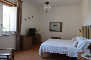 索伦托Villa Puolo - With Private Sea Access的卧室配有白色的床和电视。