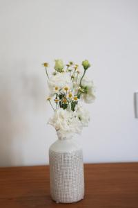 索伦托Villa Puolo - With Private Sea Access的白色花瓶,上面有白色花朵