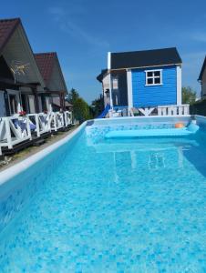 弗瓦迪斯瓦沃沃Domki letniskowe Na Stoku的蓝色房子前的游泳池