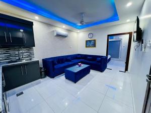JhelumPremier Heights Jhelum的客厅配有蓝色的沙发和桌子