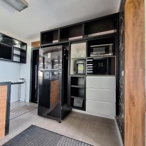 桑托斯Oceanview Santos canal 2的厨房配有黑色橱柜和冰箱。