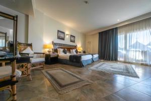 卢克索Jolie Ville Hotel & Spa Kings Island Luxor的一间卧室配有一张床、一张桌子和一张沙发