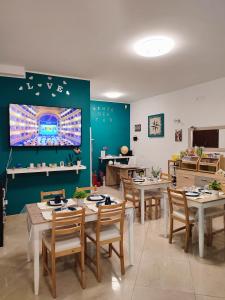 巴勒莫B&B VENTO DEL SUD的一间带桌椅和电视的用餐室