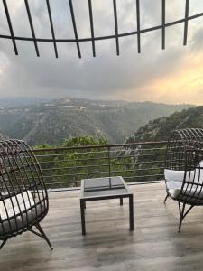 ‘AjaltūnScappa Resort的美景阳台配有两把椅子和一张桌子