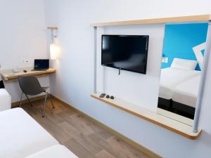 科洛米耶图卢科洛米耶宜必思快捷酒店的客房设有电视、床和书桌。