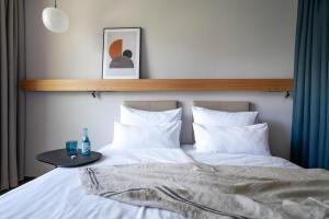 布鲁登茨Val Blu Sport | Hotel | SPA的一张带白色床单的床和一张桌子