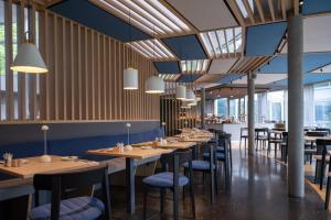 布鲁登茨Val Blu Sport | Hotel | SPA的用餐室配有木桌和椅子