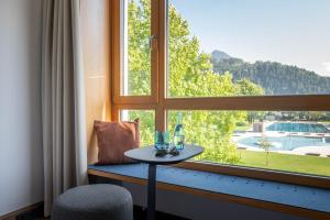 布鲁登茨Val Blu Sport | Hotel | SPA的一张桌子,位于一个设有大窗户的房间