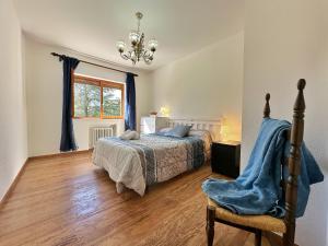 诺哈Villa La Hojarasca - 6820的卧室配有床、椅子和窗户。