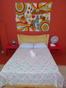 劳鲁-迪弗雷塔斯Perto Do Aeroporto De Salvador - Dona Pitanga Hostel的一间卧室配有一张带床头板的床和两张桌子