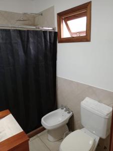 费德拉西翁Urban Hotel的浴室设有卫生间和黑色淋浴帘
