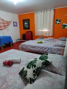 劳鲁-迪弗雷塔斯Perto Do Aeroporto De Salvador - Dona Pitanga Hostel的橙色墙壁客房的两张床