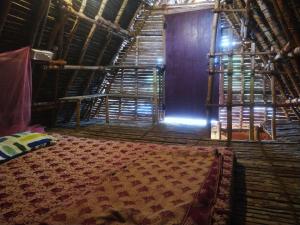 黎明之村Chords of Nature Hostels & Hut Stays Pondicherry的一间设有床铺和大地毯的房间