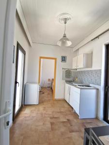 罗德镇3rd floor apartment in town with sea view的厨房配有白色橱柜和瓷砖地板。