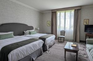 马尔戈Relais de Margaux - Hôtel & Spa的酒店客房,设有两张床和一张沙发