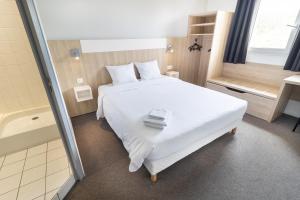 阿普瓦尼Kyriad Direct Auxerre - Appoigny的卧室配有白色的床和浴缸