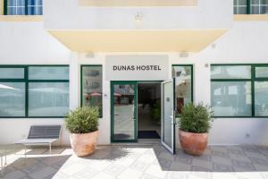 阿尔沃尔Dunas Hostel & Guesthouse的带有读读哑巴医院的标志的建筑