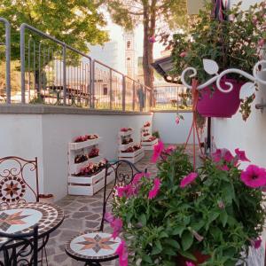 ManoppelloB&B COLLE TARIGNI的庭院里摆放着粉红色的鲜花和桌椅